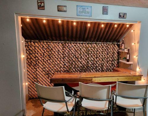 a room with a wooden table and four chairs at Trinitarias House Piscina karaoke Bar wifi in Salinas