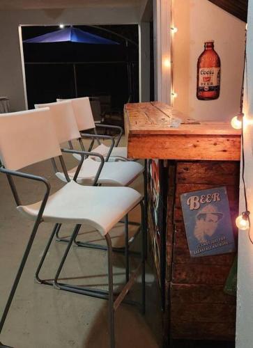 a group of chairs sitting at a bar with a table at Trinitarias House Piscina karaoke Bar wifi in Salinas