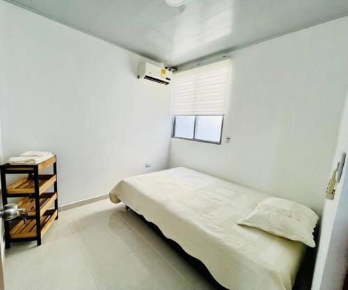 a small bedroom with a bed and a window at Alojamiento Aipe-Huila, cerca al Desierto-Tatacoa in Aipe