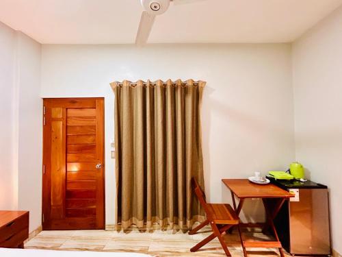 a room with a curtain and a desk and a table at Habitación Céntrica en Iquitos - Casa Alemi 5 in Iquitos
