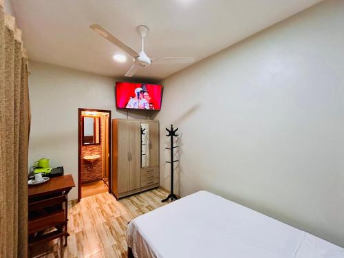 a bedroom with a bed and a tv on the wall at Habitación Céntrica en Iquitos - Casa Alemi 5 in Iquitos