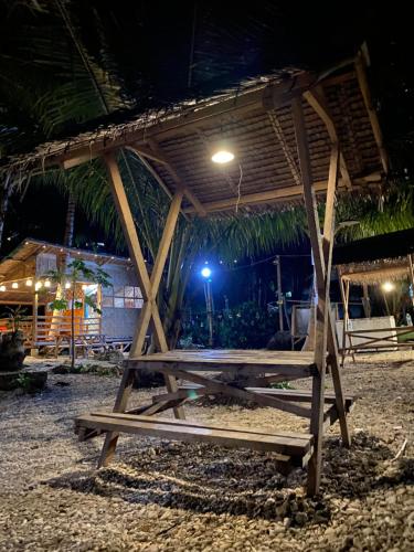 a wooden picnic table on the beach at night at Alfonsa Tent Ground - Camp By The Sea in Oslob