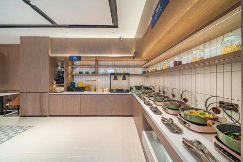 a large kitchen with many plates of food on display at Echarm Hotel Guangzhou Baiyun Station Julong Metro Station in Guangzhou