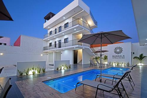 a pool in front of a building with chairs and an umbrella at Encantador departamento en el corazón de La Paz in La Paz