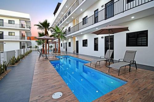 a swimming pool with chairs and an umbrella next to a building at Encantador departamento en el corazón de La Paz in La Paz