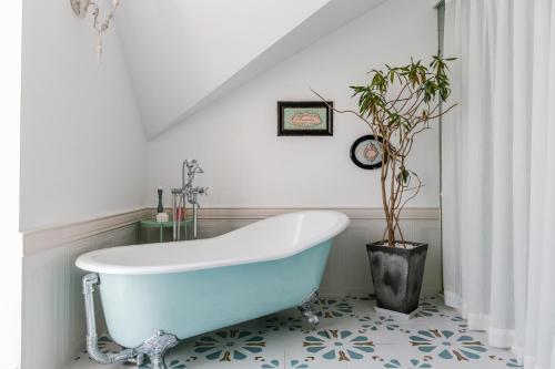a bathroom with a blue tub and a potted plant at Shanghai ruochu designer Guesthouse上海若初设计师民宿--近上海浦东国际机场及迪士尼 in Shanghai