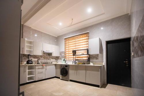 a kitchen with white cabinets and a black door at SMK Apartment in Ho