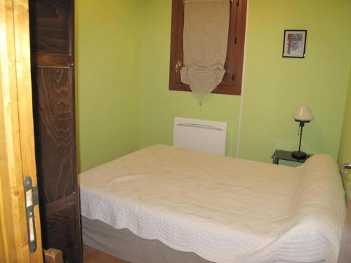 a bedroom with a bed in a green room at Charmant 2 Pièces, Balcon, Wi-Fi, Proche Pistes, Chantemerle - FR-1-762-9 in Saint-Chaffrey