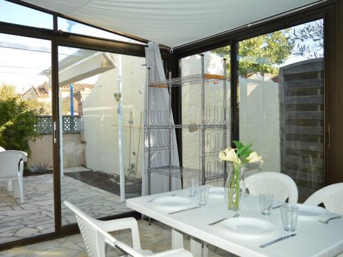 - une table blanche avec un vase de fleurs sur la terrasse dans l'établissement Maison avec terrasse et clim, proche plage - FR-1-225-825, à Argelès-sur-Mer