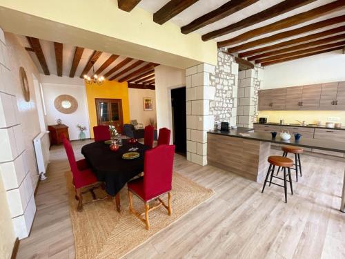 une cuisine et une salle à manger avec une table et des chaises rouges dans l'établissement Gîte tout confort avec garage et WIFI à Preuilly-sur-Claise - FR-1-381-596, à Preuilly-sur-Claise