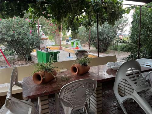 a table and chairs with a playground in the background at Villa Rural El doncel in Hellín