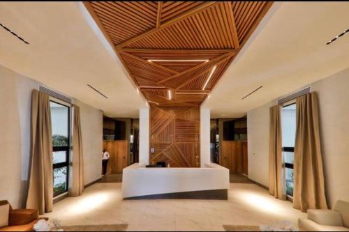 a living room with a wooden ceiling with windows at Luxury Santo Domingo Tower Condo in Santo Domingo