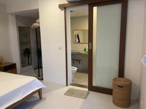 a bedroom with a bed and a bathroom with a toilet at Base Villa in Canggu