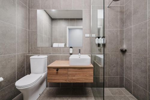a bathroom with a toilet and a sink and a shower at Abode Murrumbateman in Murrumbateman