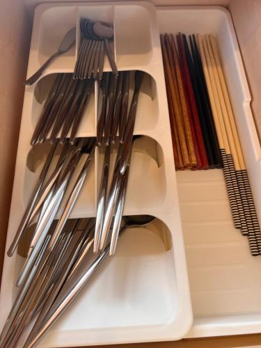 a drawer full of utensils in a drawer at Asahi House in Hiyakon