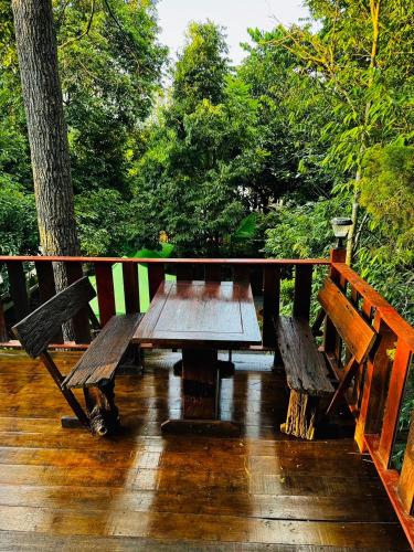 a wooden table and benches on a deck at อิงภูเมาท์เท่นวิว เขาใหญ่ in Ban Khan Takhian