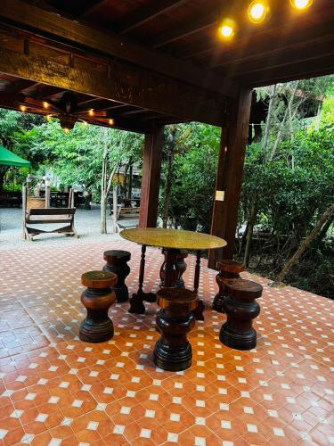 a table and stools sitting on a patio at อิงภูเมาท์เท่นวิว เขาใหญ่ in Ban Khan Takhian
