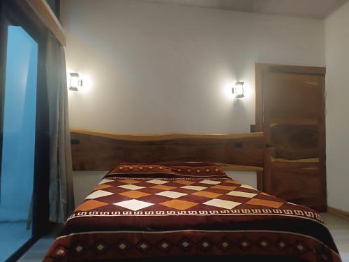 a bed in a room with a checkered blanket on it at Athila Ecolove in Monteverde Costa Rica