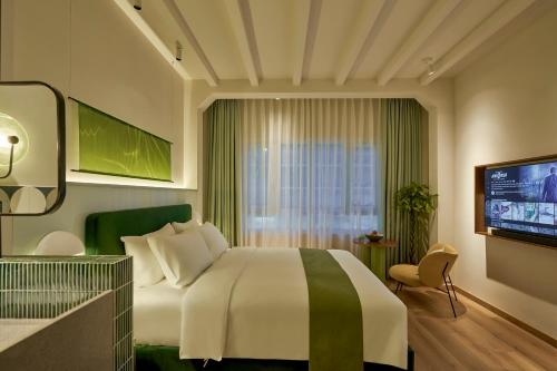 a hotel room with a bed and a television at The Urban Resort by CIRCADIAN in Ho Chi Minh City