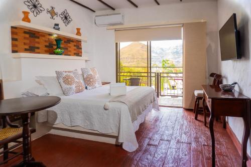 une chambre avec un lit, une fenêtre et une table dans l'établissement Honda Colonial Magdalena Resort, à Honda