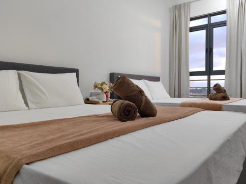 two beds with teddy bears sitting on top of them at Near Airport K Avenue Family Room in Donggongon