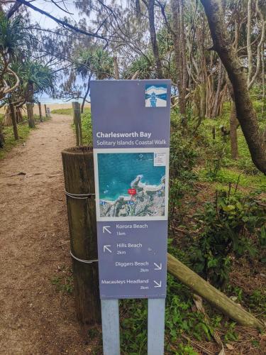 a sign on the side of a trail at Charlesworth Bay Beach Resort in Coffs Harbour