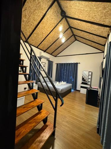 a bedroom with a bed and stairs in a room at อิงภูเมาท์เท่นวิว เขาใหญ่ in Ban Khan Takhian