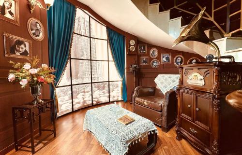 a living room with a chair and a window at Shanghai Park Hotel - Hudec Excellent Historical Building - Priority Access for Classic Butterfly Cookies Without queuing to guests in Shanghai