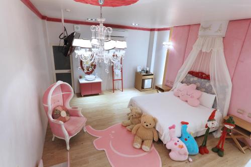 a bedroom with a bed with stuffed animals on the floor at Follow Me designed B&B in Dongshan