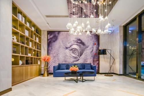 a living room with a blue couch and a table at Echarm Hotel Chongqing Dadukou Commercial Center Xinshancun Metro Station Branch in Dadukou