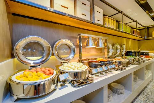 a buffet line with pots and pans of food at Echarm Hotel Chongqing Dadukou Commercial Center Xinshancun Metro Station Branch in Dadukou