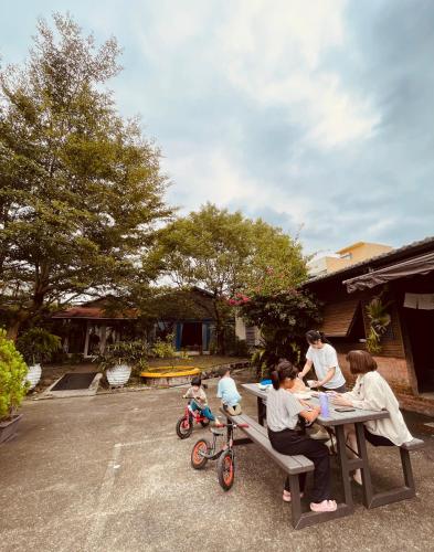 a family sitting at a picnic table with a child on a bike at Follow Me designed B&B in Dongshan