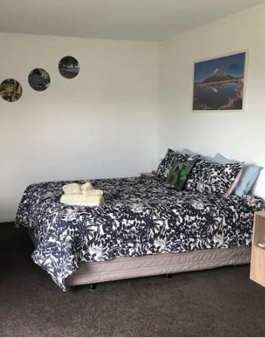 a bedroom with a bed with a black and white comforter at Raz & Louises bnb in Otorohanga