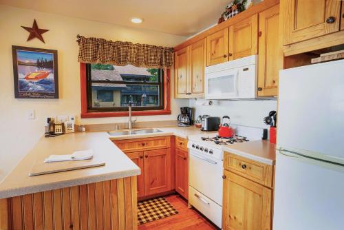 a kitchen with wooden cabinets and a white refrigerator at On The Beach in Tahoe Vista