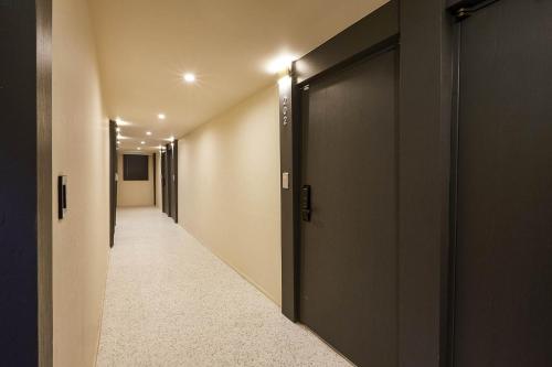 a hallway with two doors and a hallway with a corridorngthngthngth at vane hotel in Incheon