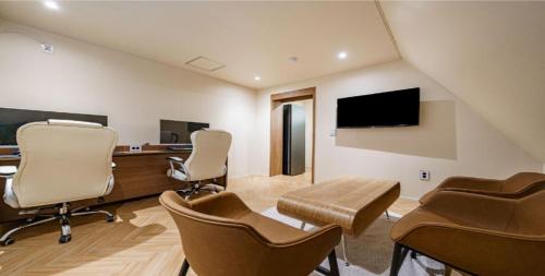 a room with chairs and a desk and a tv at vane hotel in Incheon