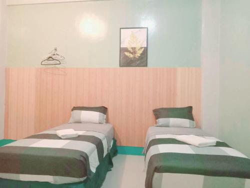 a room with two beds in a room at Dreamway House Bed & Breakfast in Roxas City