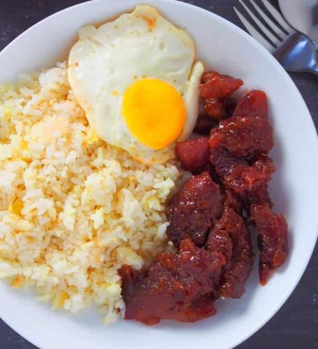 a bowl of rice with an egg on top at Dreamway House Bed & Breakfast in Roxas City