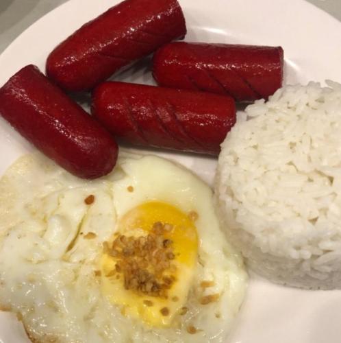 a plate of food with sausage and rice on it at Dreamway House Bed & Breakfast in Roxas City