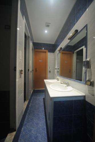 un bagno con due lavandini e un grande specchio di Hotel Beauty a Roma