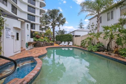 a swimming pool in front of a building at Seascape Sanctuary - Palm Beach Resort-style Bliss in Gold Coast
