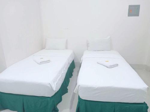 two beds sitting next to each other in a room at Dreamway House Bed & Breakfast in Roxas City