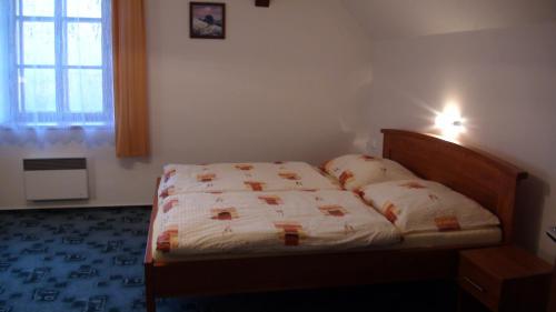 a bedroom with a bed in a room with a window at Penzion Taferna in Žďár nad Sázavou