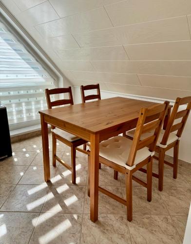 a wooden table and chairs in a room at BERlin Apartment - Naturnah & Startklar in Eichwalde