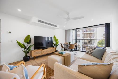 a living room with a couch and a tv at The Shores Surfers Paradise Apartments in Gold Coast