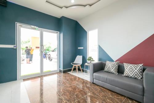 a living room with blue walls and a couch at The Wish Hotel in Chachoengsao