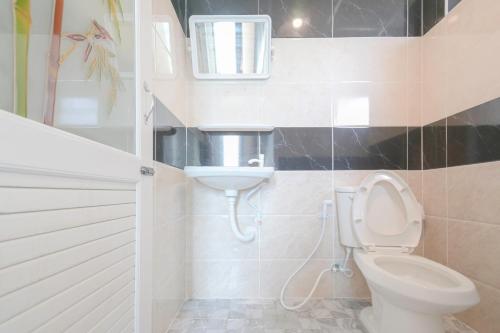 a bathroom with a toilet and a sink at The Wish Hotel in Chachoengsao