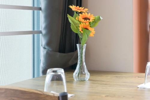 a vase filled with orange flowers sitting on a table at The Wish Hotel in Chachoengsao