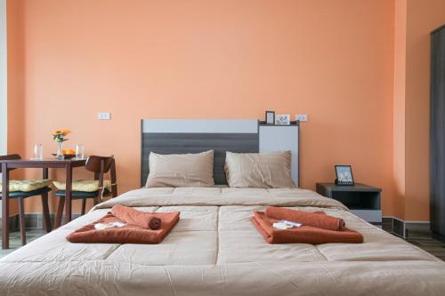 a bedroom with a large bed with two pillows on it at The Wish Hotel in Chachoengsao
