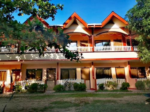 a large house with a white fence at JBR Tourist Inn II - Port Barton in Port Barton